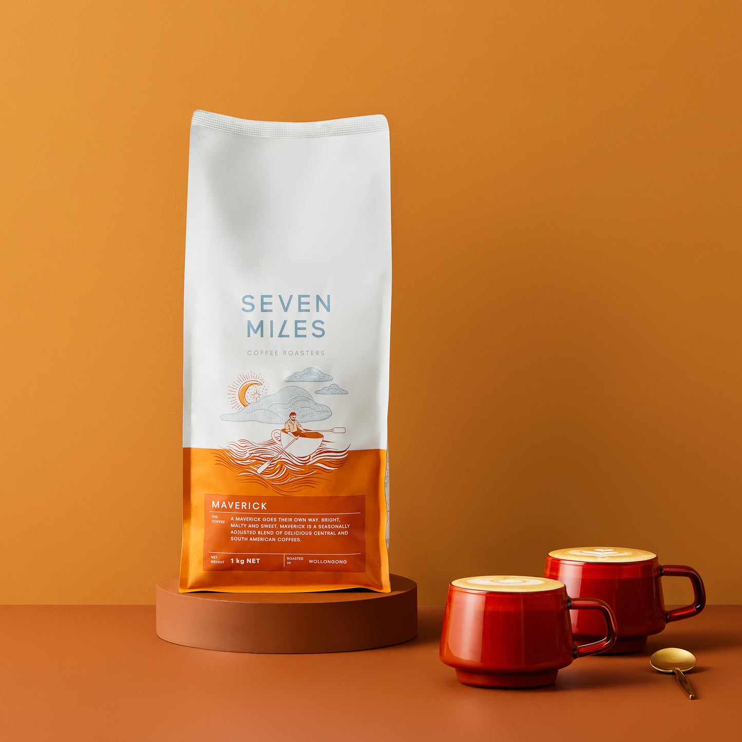 1kg of Maverick Coffee with two red glasses of coffee and a gold teaspoon