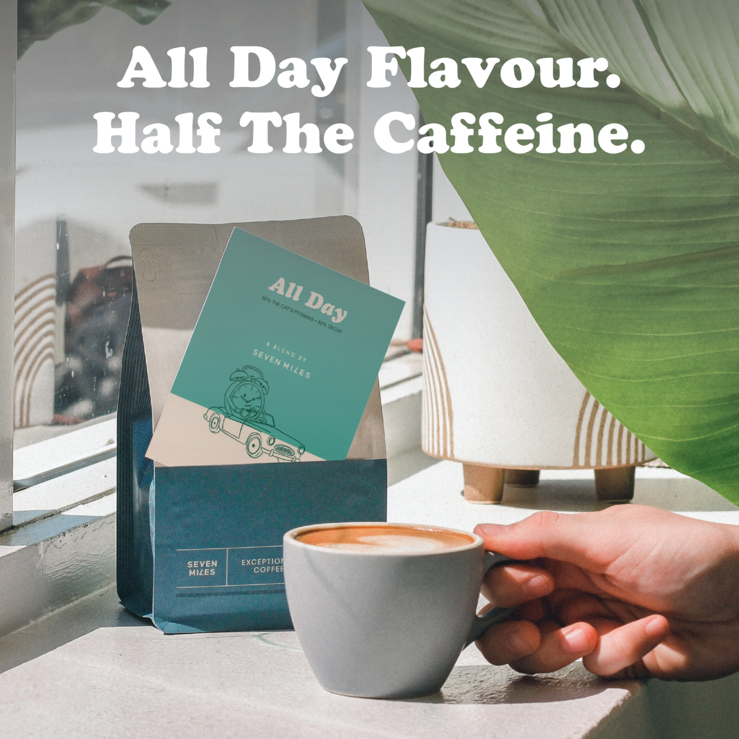 Cup of coffee with a hand holding it, next to a bag of All Day Half Caff with text 'All Day Flavour. Half The Caffeine.'