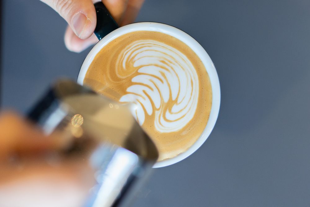 latte art milk pouring into cup
