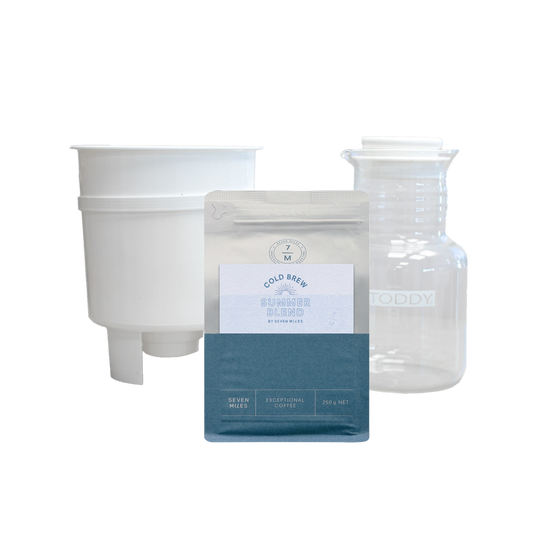 A product bundle featuring a white plastic funnel, a clear glass decanter with 'TODDY' printed on it, and a silver and teal pouch of 'Gold Reef' Coffee Roaster Blend.