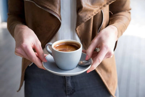 woman standing and holding coffee in front of her