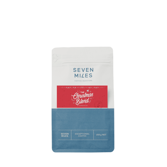 Seven Miles Coffee Roasters Christmas Blend packaging on a white background, festive holiday coffee bag design featuring the Seven Miles logo and seasonal colors.
