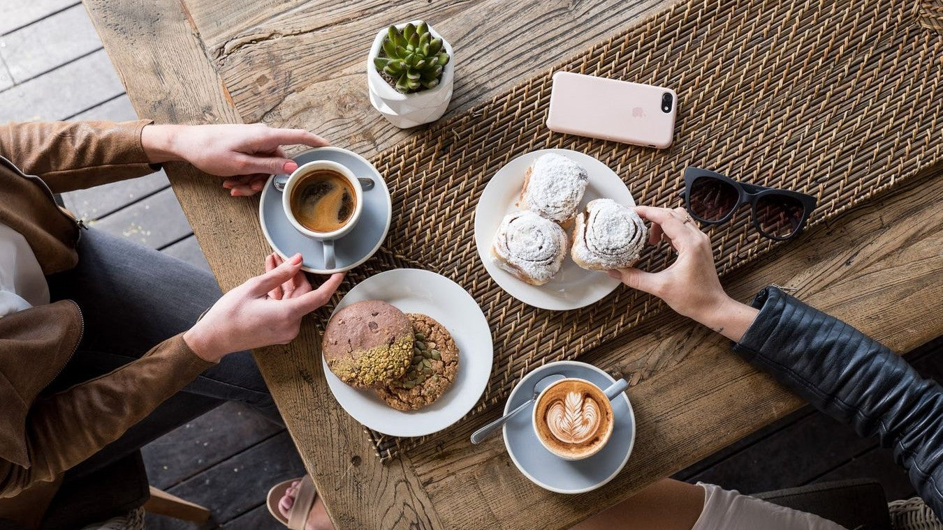 two people enjoying a meal and coffee at cafe